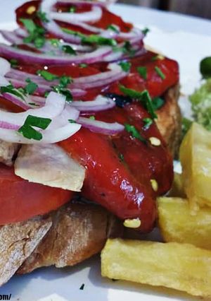 Una foto de Tosta de ventresca con pimientos rojos asados, cebolla roja y tomate raf