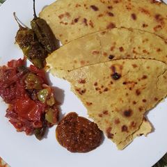 A picture of Besan ki Roti.Piyaz Tamatar Hari Mirch Chutney.
