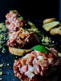 Tartar de fuet con tomates secos en aove y polvo de morro tostado