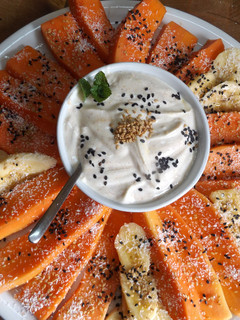Una foto de Fuente de papaya y plátano con salsa y coco