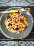 Fideos de arroz fritos con atún marinado y verduras