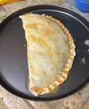 Empanada gigante de cebolla, tomate y queso envuelta en hojas de espinacas
