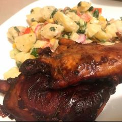 A picture of Baked chicken in BBQ sauce and potato salad.