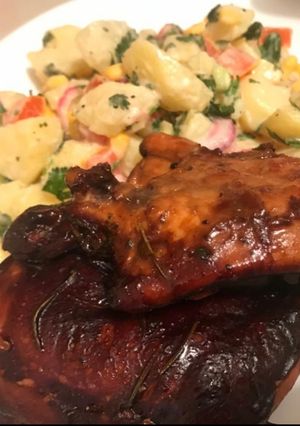 A picture of Baked chicken in BBQ sauce and potato salad.