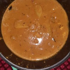 A picture of Red gravy with aloo.