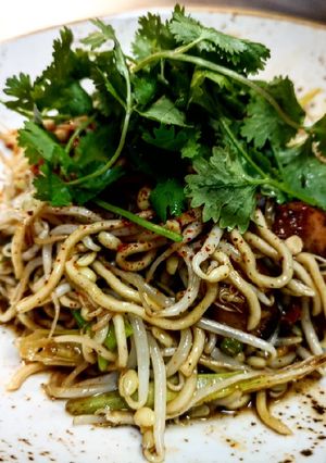 A picture of Wok egg noodles with salmon bites.