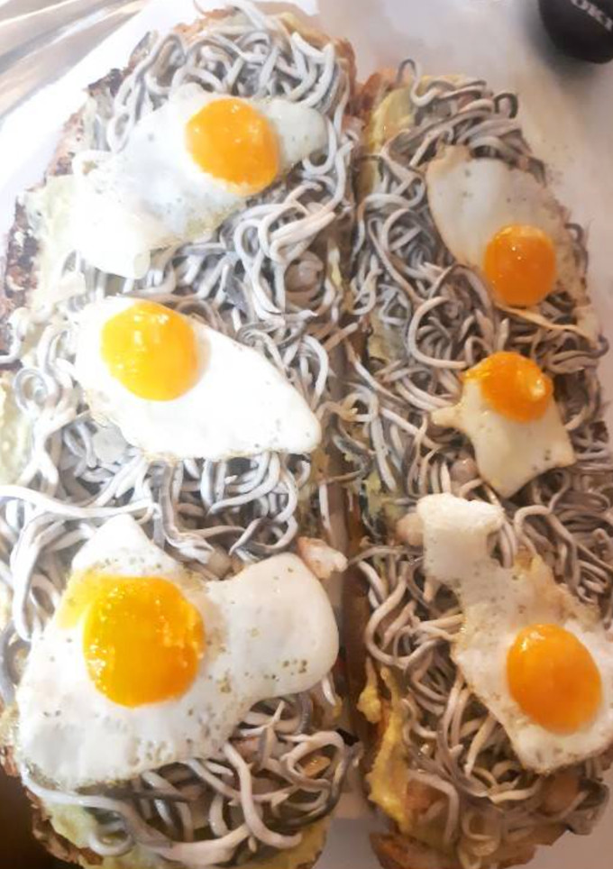 Una foto de Tostada de gulas y huevos de codorniz