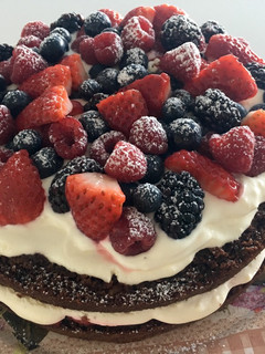 Una foto de Tarta de chocolate con crema y frutos rojos