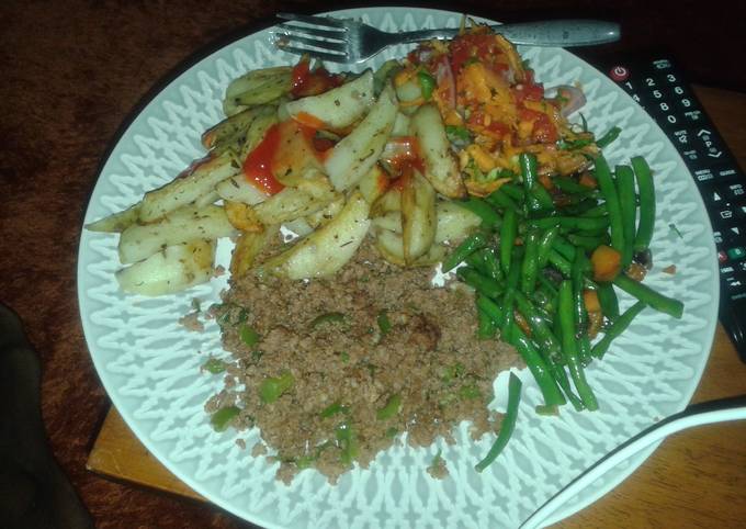 Potato wedges served with minced meat, fried French beans and kachumbari