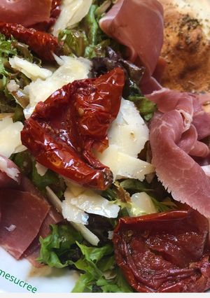Une photo de Chausson chèvre sur lit de salade tomates séchées, jambon de parme, parmesan