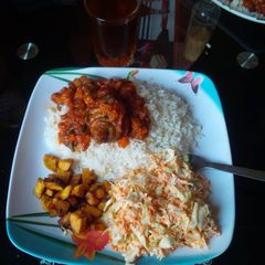 A picture of White rice with stew,fried plantain and Coleslaw.
