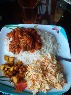 A picture of White rice with stew,fried plantain and Coleslaw.