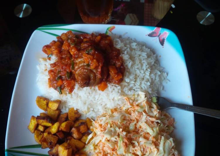 White rice with stew,fried plantain and Coleslaw