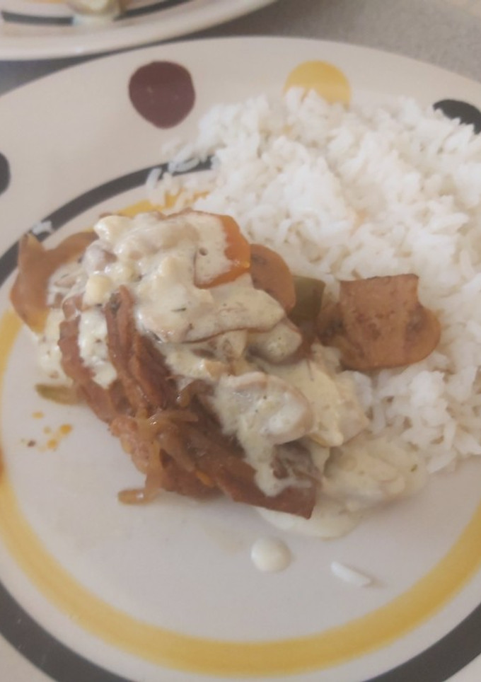 Una foto de Carne con salsa de champiñones y arroz blanco