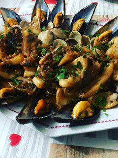 Una foto de Sepia encebollada con almejas y mejillones al vapor