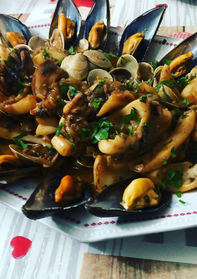 Una foto de Sepia encebollada con almejas y mejillones al vapor