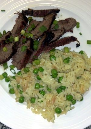 A picture of Thai flank steak with rice pilaf.