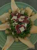 Ensalada de peras, uvas y rúcula con viruta de ibérico de bellota y parmesano y su aliño