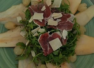 Una foto de Ensalada de peras, uvas y rúcula con viruta de ibérico de bellota y parmesano y su aliño