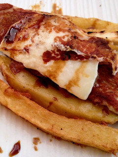 Una foto de Pincho de solomillo, queso de cabra y jamón sobre nido de patatas fritas
