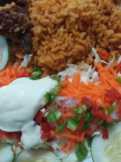 A picture of Simple party jollof rice with salad.