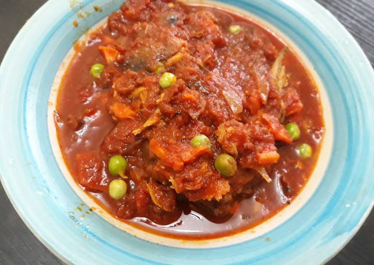 Tomatoes stew with fish and green peas
