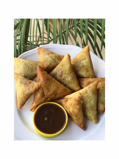 A picture of Samosa and a chutney.
