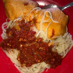 A picture of Pasta with pepper sauce and moi moi.