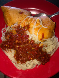 A picture of Pasta with pepper sauce and moi moi.