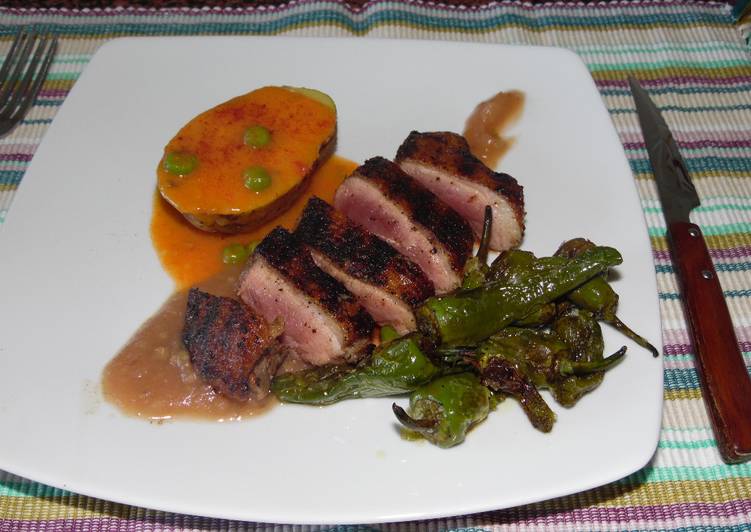 Pechuga de pato asada con pimientos del padrón, papa con salsa de carne guisantes y puré de manzana