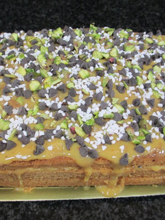 Una foto de Tarta sencilla con leche condensada, pepitas de chocolate y pistachos