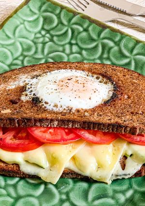 O poză a rețetei Sandviș cu ou în gaură, avocado, Emmental și felii de roșie.