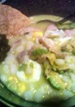 A picture of cuernavaca style white pozole with chicken.