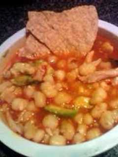 A picture of pozole with chicken.