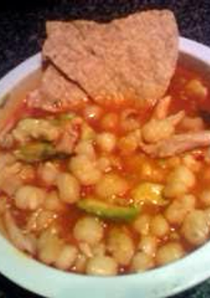A picture of pozole with chicken.
