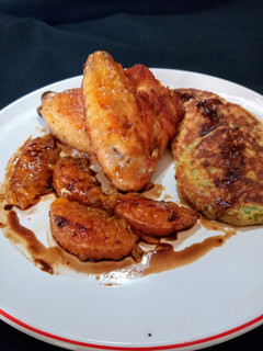 Una foto de Alitas de pollo al horno. Guarnición: blinis de papas y gajos de mandarina caramelizados