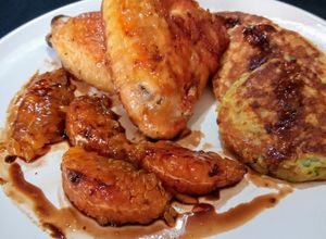 Una foto de Alitas de pollo al horno. Guarnición: blinis de papas y gajos de mandarina caramelizados