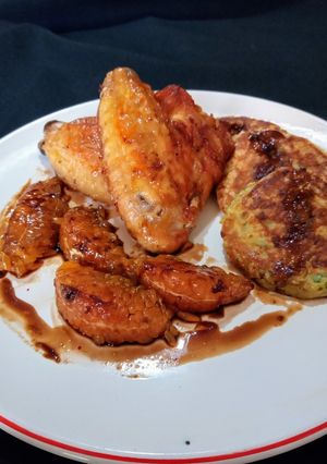 Una foto de Alitas de pollo al horno. Guarnición: blinis de papas y gajos de mandarina caramelizados