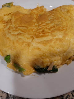 Una foto de Tortilla de espinacas, piñones y rulo de cabra