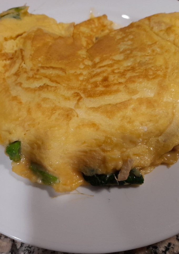 Una foto de Tortilla de espinacas, piñones y rulo de cabra