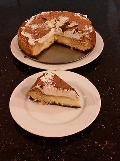 A picture of Vanilla / Peanut Butter Ice Cream Cake with a Crispy Crust and Whipped Cream Topping With Creamy Crispy Chicolate Bark.