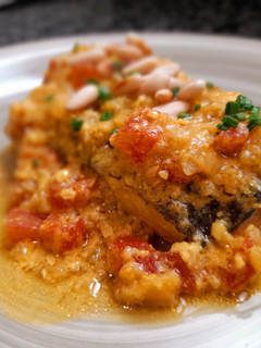 Una foto de Merluza en salsa de azafrán y piñones con tomate concasse