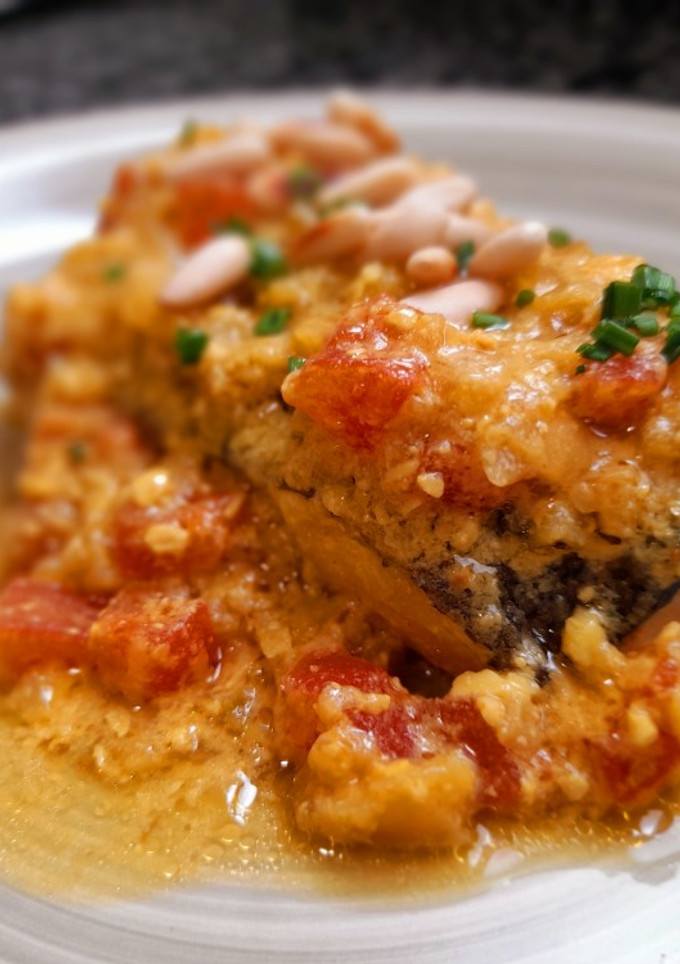 Una foto de Merluza en salsa de azafrán y piñones con tomate concasse