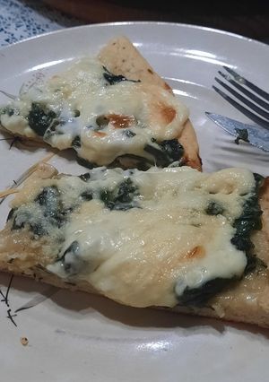Una foto de Pizza blanca de espinacas y quesos