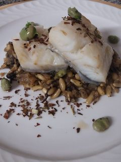 Una foto de Bacallà cuinat a baixa temperatura sobre un llit de sofregit amb pols de vegetals,faves caramel·litzades salsa de bolets