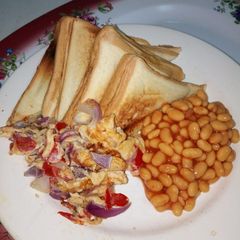 A picture of Toasted Bread with Fried Eggs and Baked Beans.