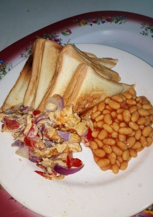 A picture of Toasted Bread with Fried Eggs and Baked Beans.