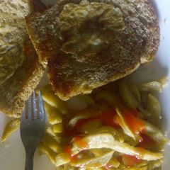 A picture of Egg in a hole with a side of fries.