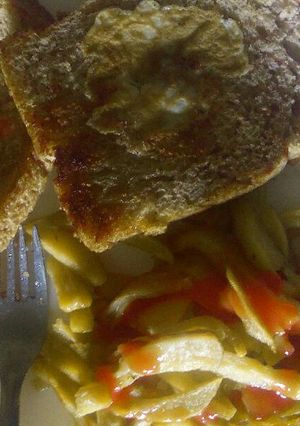 A picture of Egg in a hole with a side of fries.
