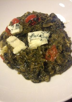 A picture of Dandelion Ka Saag. with grape tomatoes and blue cheese.